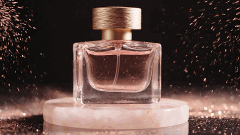 Cinematic 360-degree studio orbit around a translucent pale pink glass perfume bottle