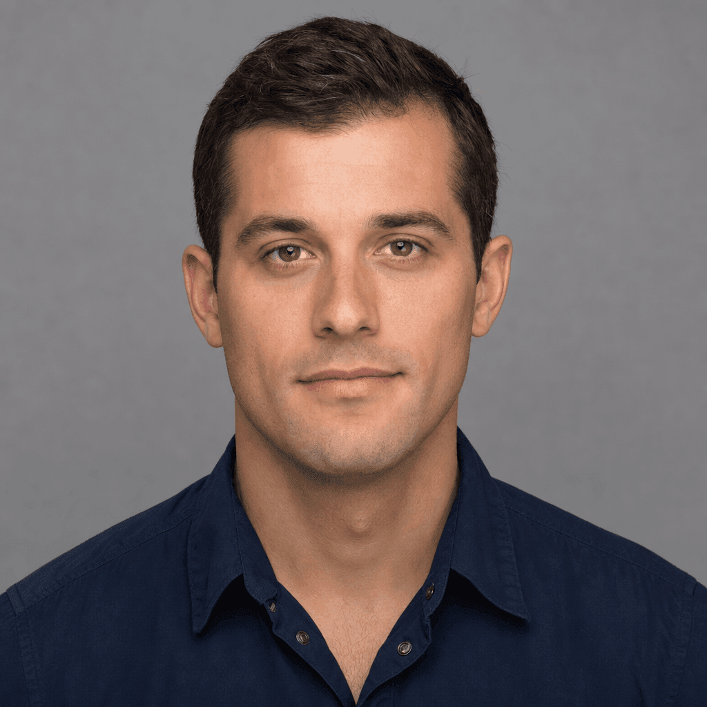 Headshot of a man with dark hair wearing a blue shirt