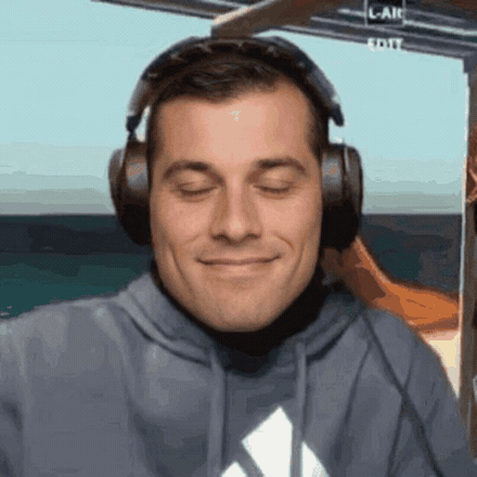 Smiling man with closed eyes wearing large over-ear headphones