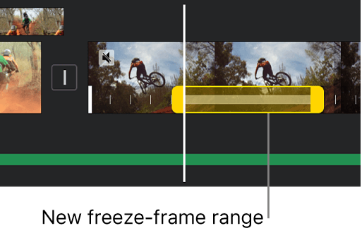 Screenshot of the iMovie timeline on iPhone showing a freeze frame inserted into a mountain-biking clip, with the frozen section marked by a yellow bar with handles at each end, starting at the playhead position Screenshot from Apple's iMovie User Guide for iPhone, Adjust video speed in iMovie on iPhone.