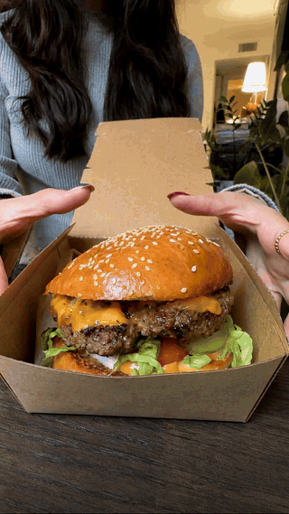 MiniMax H3 food video burger UGC review GIF with a creator opening a burger box and taking a bite