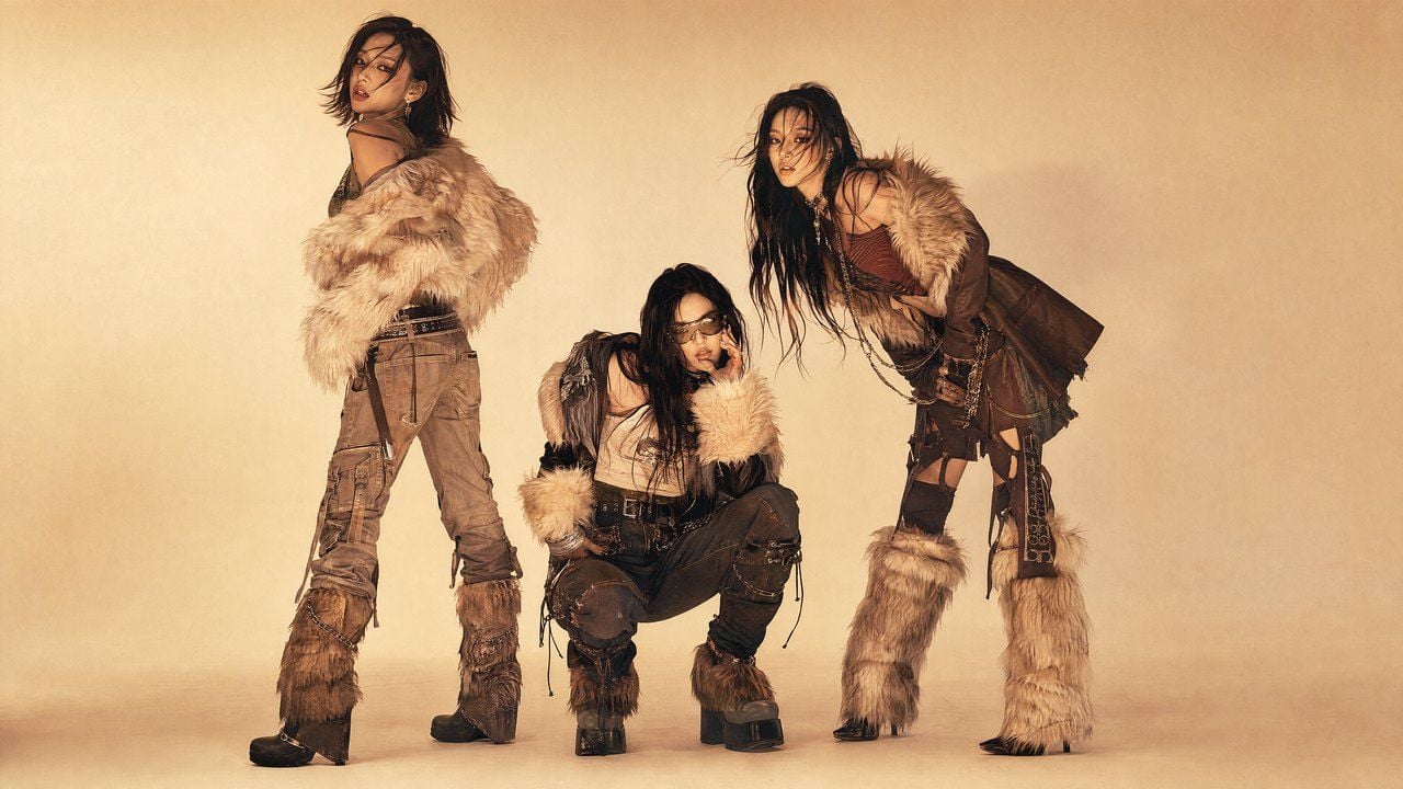 Three women posing in distressed outfits with faux fur accents