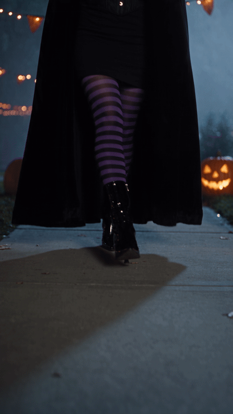 Ramalama costume walk AI video made with Seedance 2.5 from one portrait, showing a ground-level walk in striped stockings and boots, a tilt up to a witch in a pointed hat and long cape, and a hat-tip pose