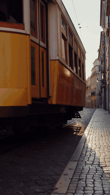 Ten-second vertical Seedance 2.5 teaser made through the Atlas Cloud plugin in ChatGPT: a Lisbon tram passing in golden light, a red-haired woman turning to smile on a viewpoint, then a hand picking up a pastel de nata
