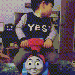 Toddler riding a Thomas the Tank Engine toy train