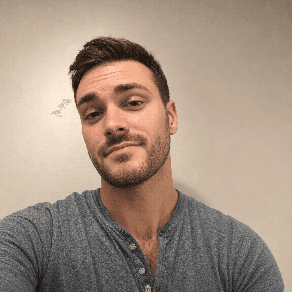 Smiling man with stubble wearing a blue henley shirt