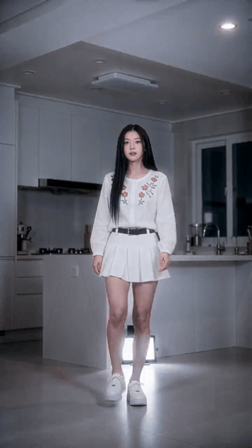 Donna con camicetta bianca ricamata e gonna a pieghe in una cucina