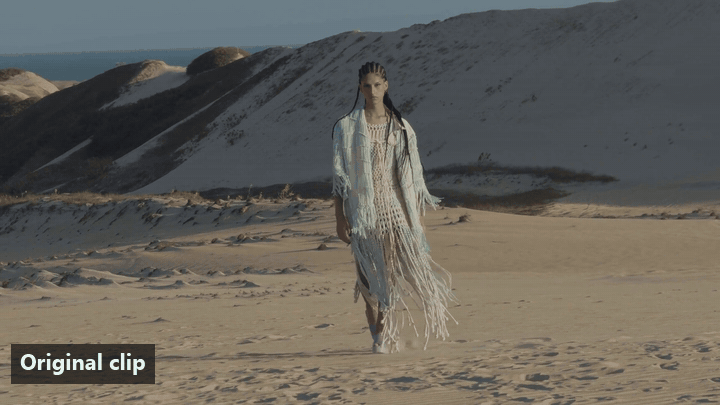 The last 3 seconds of an 8-second clip of a woman in a pale mint fringed crochet shawl walking toward the camera across white sand dunes, followed by the 10 seconds Grok Imagine added on Atlas Cloud, with an on-screen label that switches from Original clip to Extended by Grok Imagine at the join