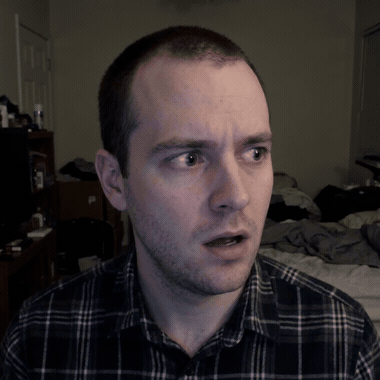 Man in a plaid shirt looking shocked and confused